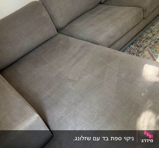 ספה אפורה נקייה עם שטיח צבעוני